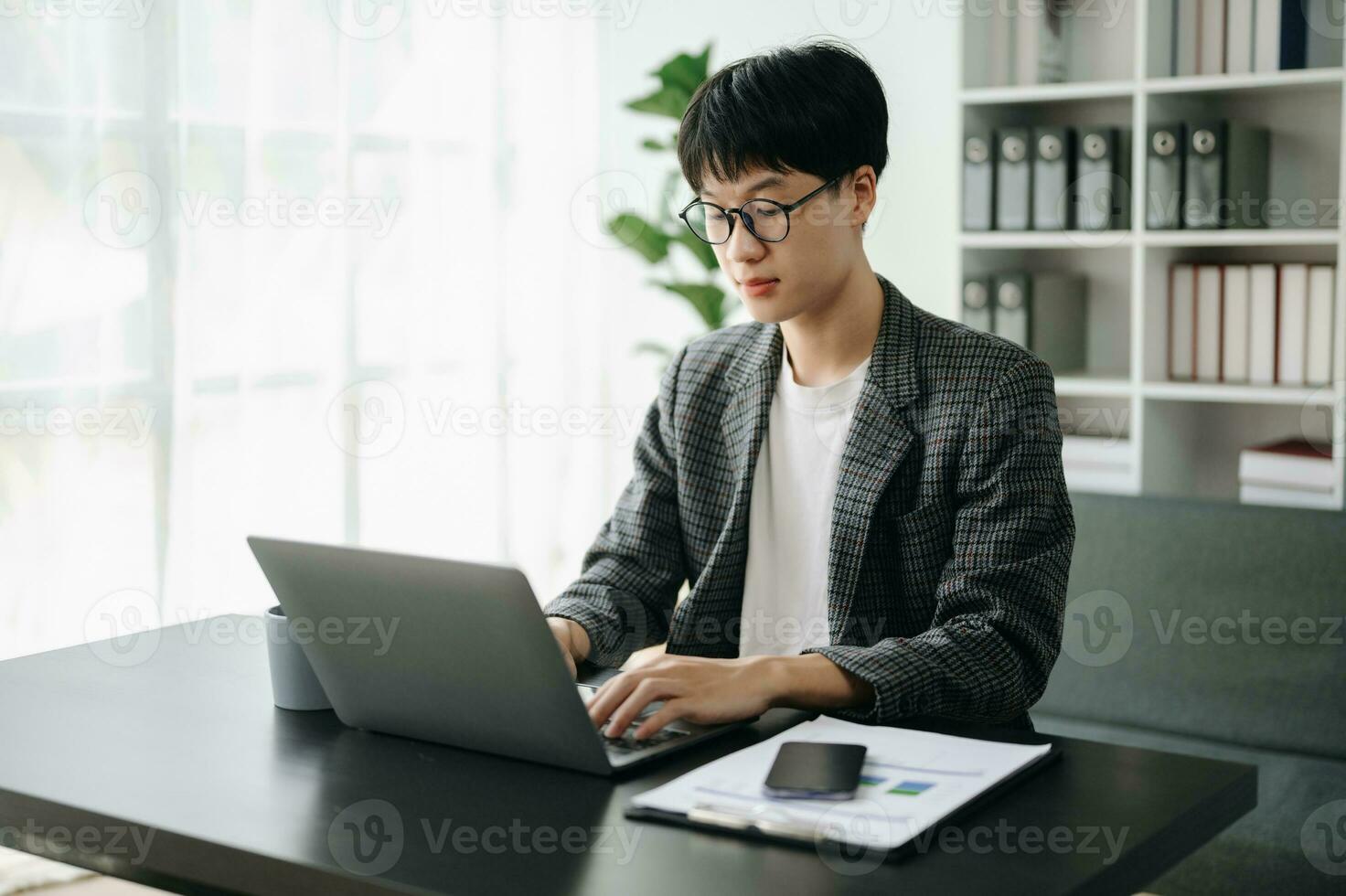 Young business man executive manager looking at laptop watching online webinar training or having virtual meeting video conference doing market research working in office. photo