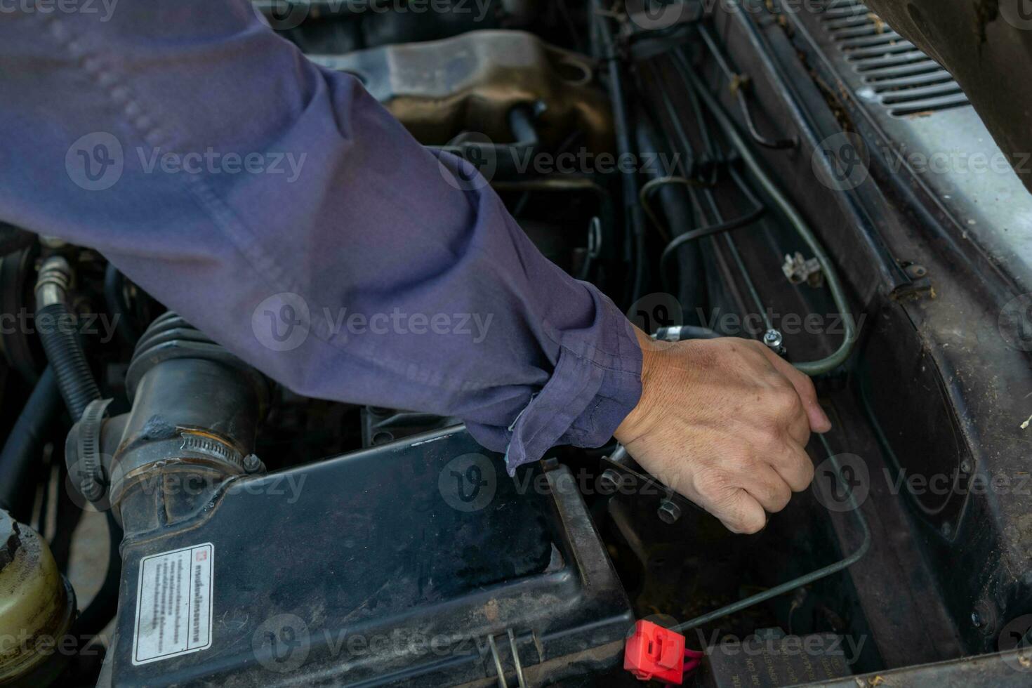 car mechanic is checking condition of engine to make it ready for use and mechanic is still maintaining worn out equipment to return to normal operation. checking engine conditions before traveling photo