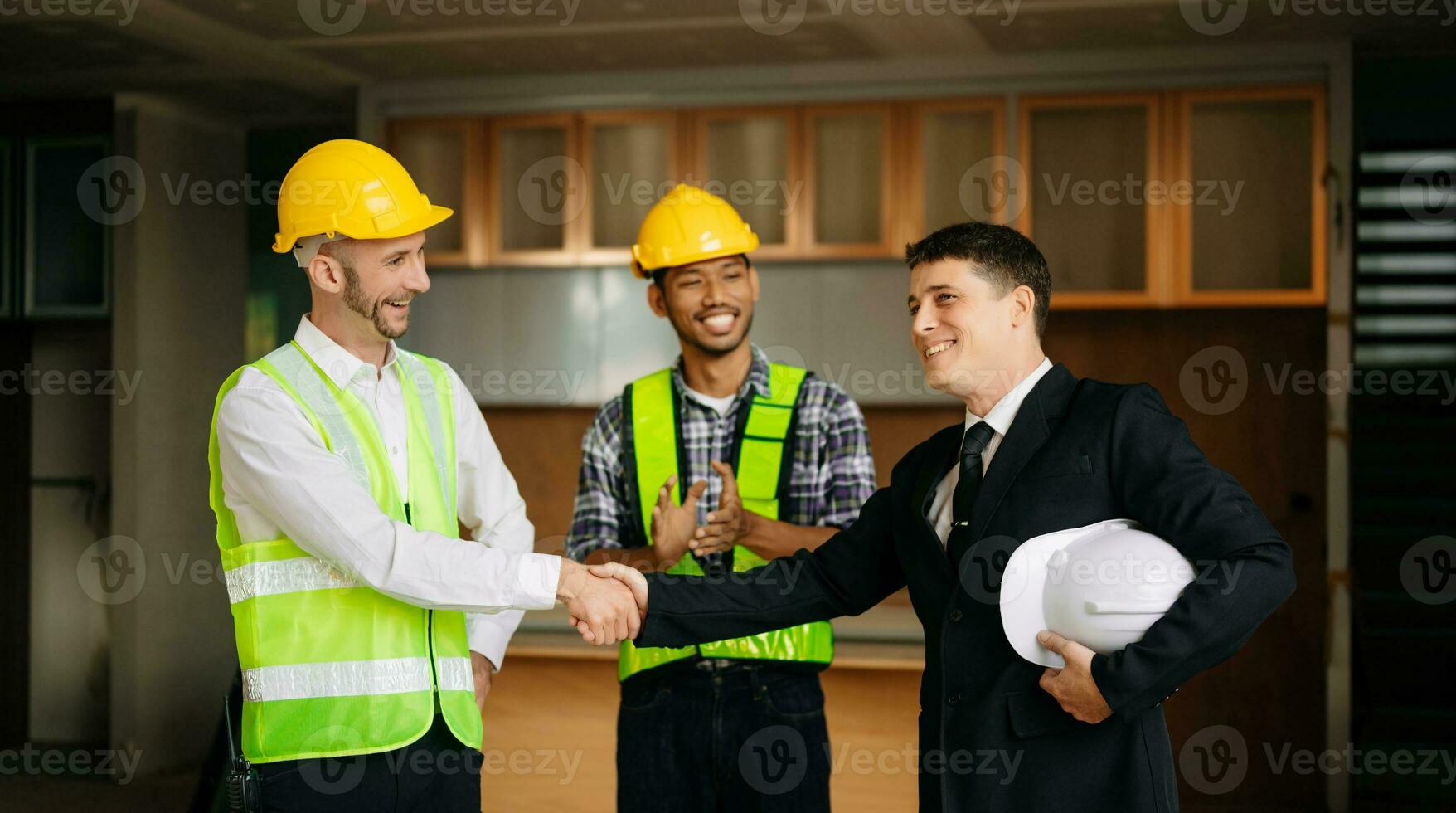 Engineers or architecture shaking hands at construction site for architectural project, holding safety helmet on their hands. successful cooperation photo