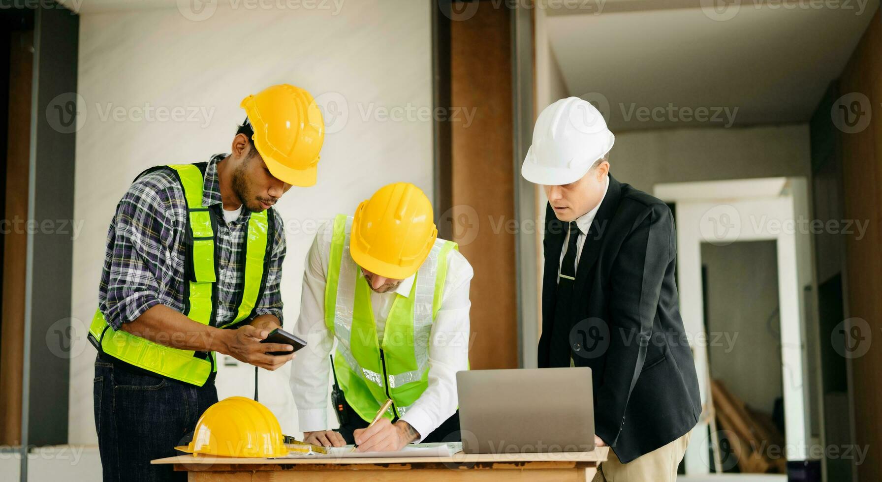 Architect caucasian man working with colleagues mixed race in the construction site. Architecture engineering on big project. Building in construction process photo