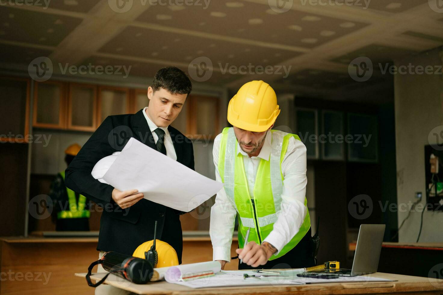 Engineers are discussing data working and laptop or tablet with architectural project at new construction site on big project. interior photo