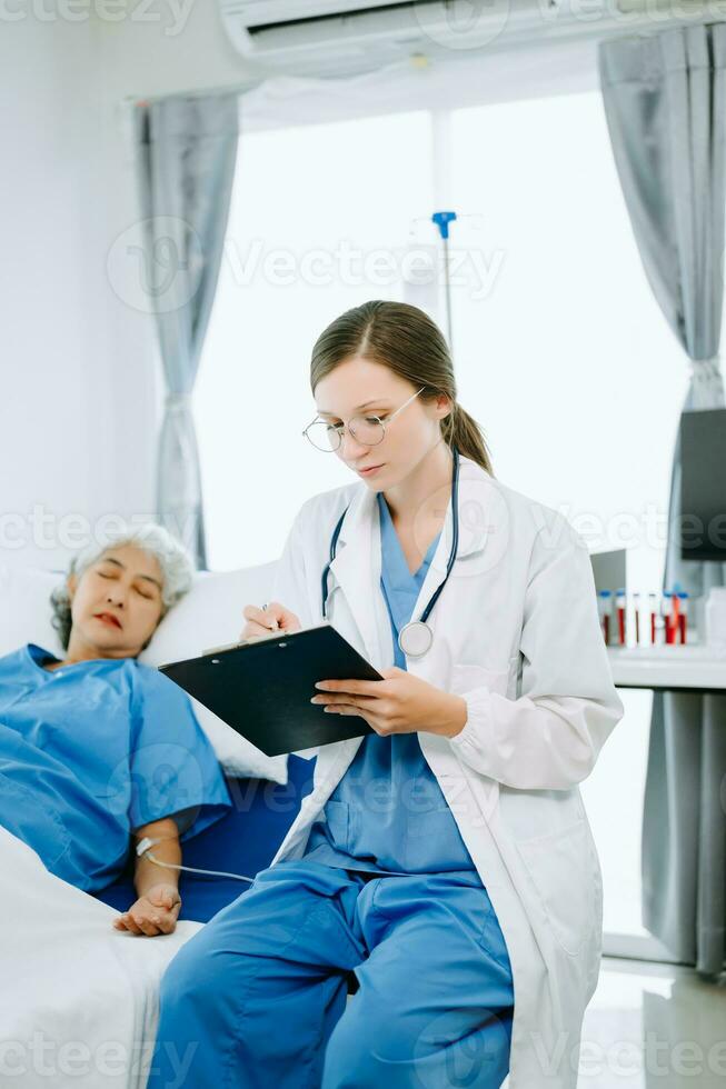 Caucasian doctor smiling take care of a senior patient in hospital. Friendly nurse or therapeutic treat client Professional medical service concept. photo