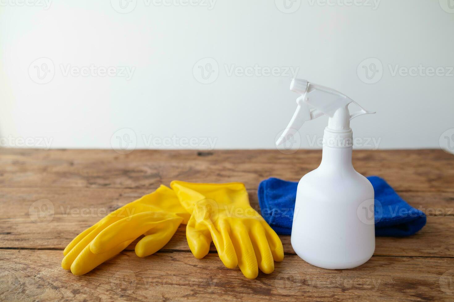 blue towel and yellow gloves were placed on wooden table for cleaning staff to use to clean and prevent cleaner from dermatitis. concept of choosing cleaning company to clean the office photo