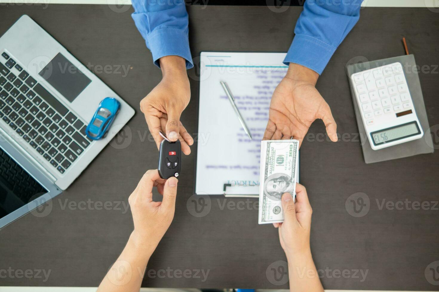 The car showroom car dealer handed over the keys to the customer after the purchase contract was finalized. The concept of buying and selling car with a trusted dealer for peace of mind. photo