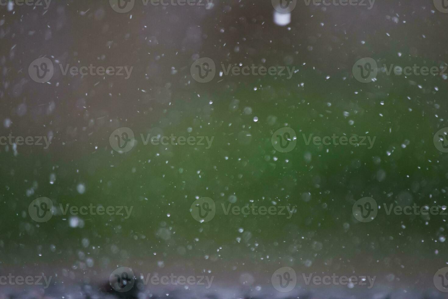 Background of many rain drops falling on the ground due to heavy rain during the rain season causing water splashing from a large number of plots on a blurred background of dark spray. photo