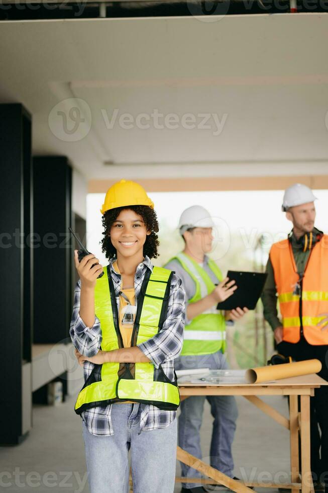 Contractor and architect looking at plan, tablet, laptop and talking about working on big project. Building in construction process interior. team work photo