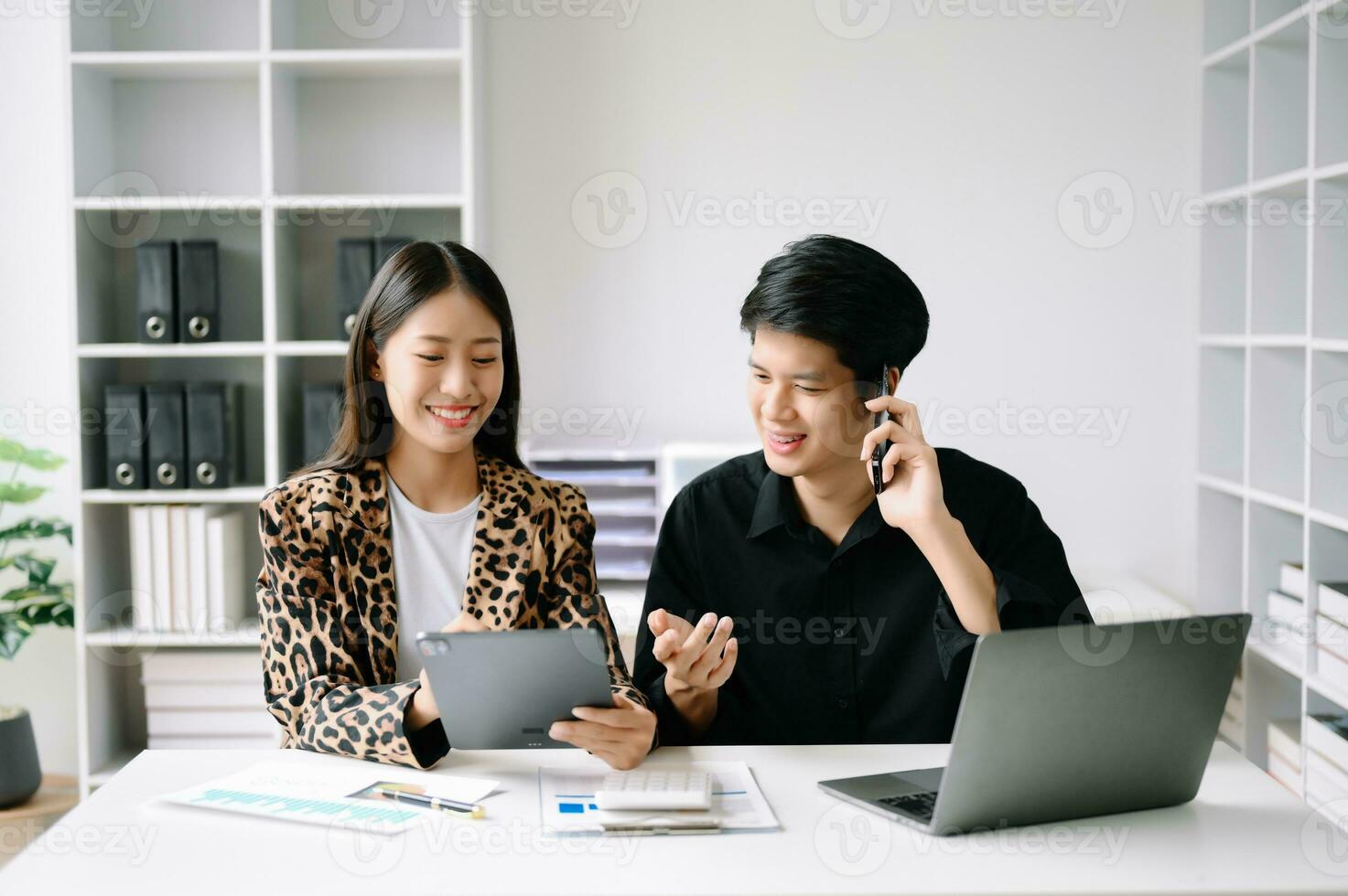 Two Asian business woman and man  discuss investment project working and planning strategy with tablet laptop computer in office. photo