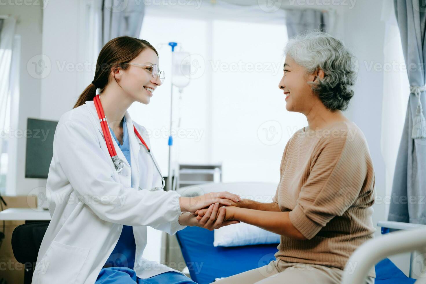 Friendly Female Head Nurse Making Rounds does Checkup on Patient Resting in Bed. She Checks tablet while Man Fully Recovering after Successful Surgery in hospital photo