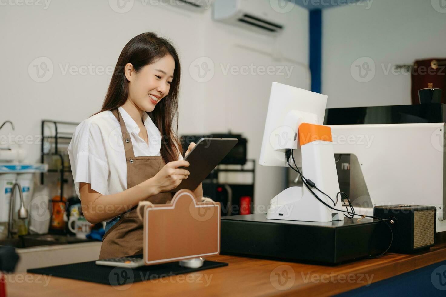 Asian female coffee shop owner in a coffee shop photo