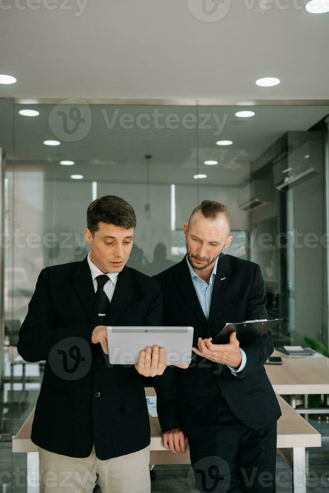 Kind leader executive manager share and discuss business solutions plan ideas on tablet with male marketing manager in modern office. photo