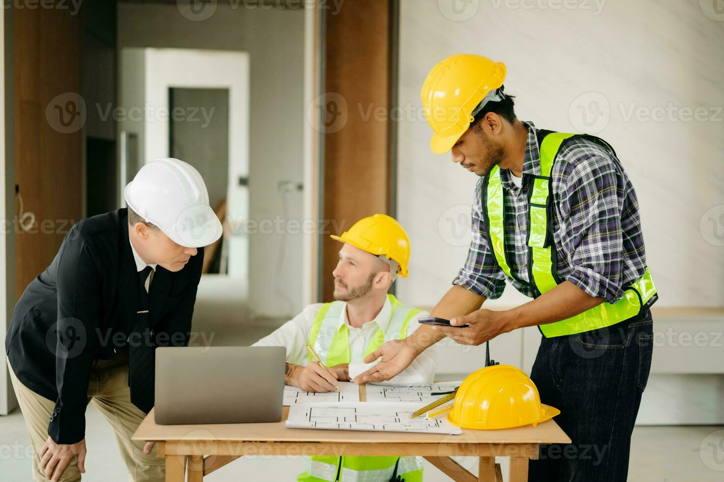 Architect caucasian man working with colleagues mixed race in the construction site. Architecture engineering on big project. Building in construction process photo