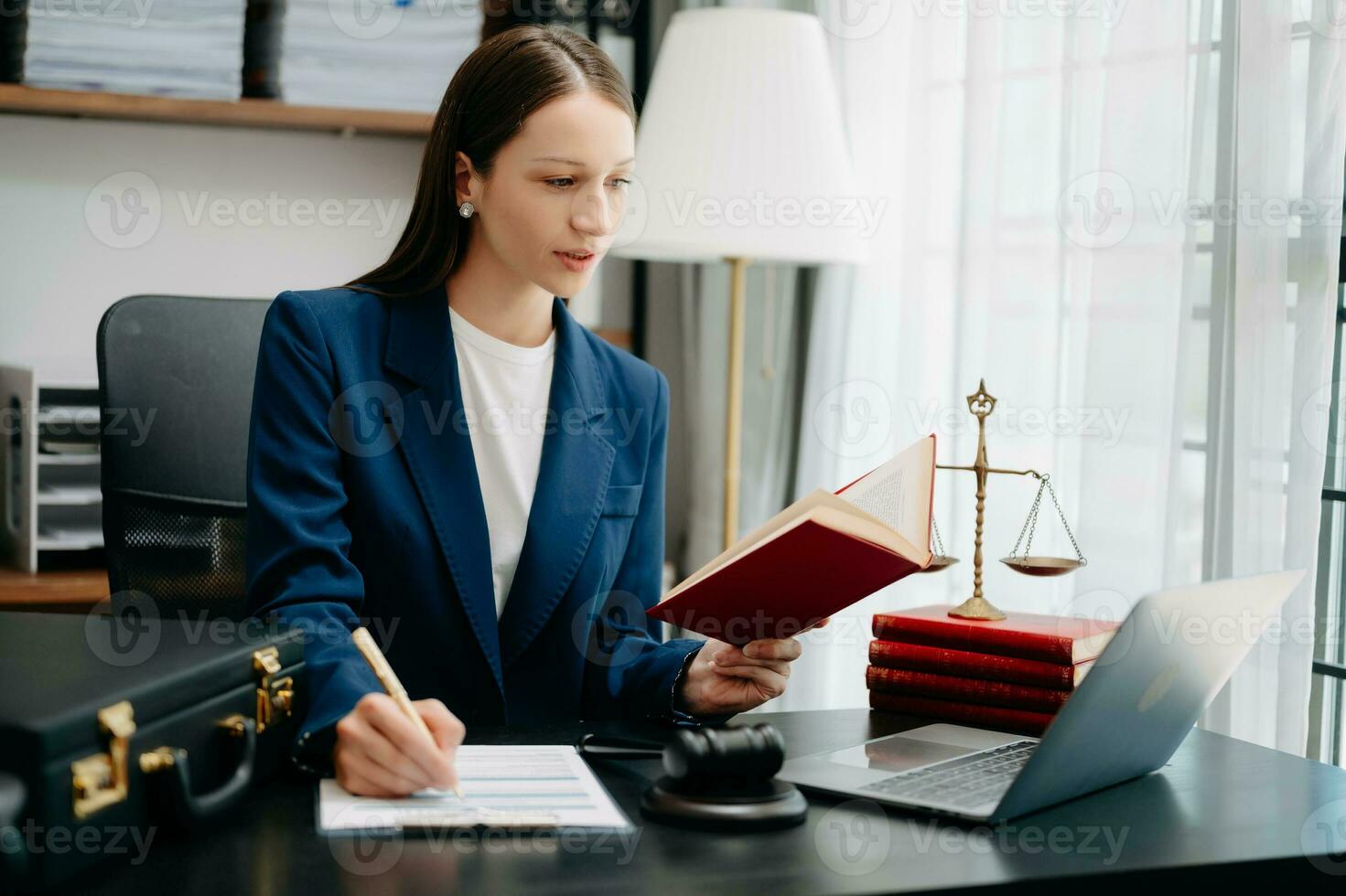 Caucasian Woman lawyer reading legal book with gavel on table in office. justice and law ,attorney concept. photo