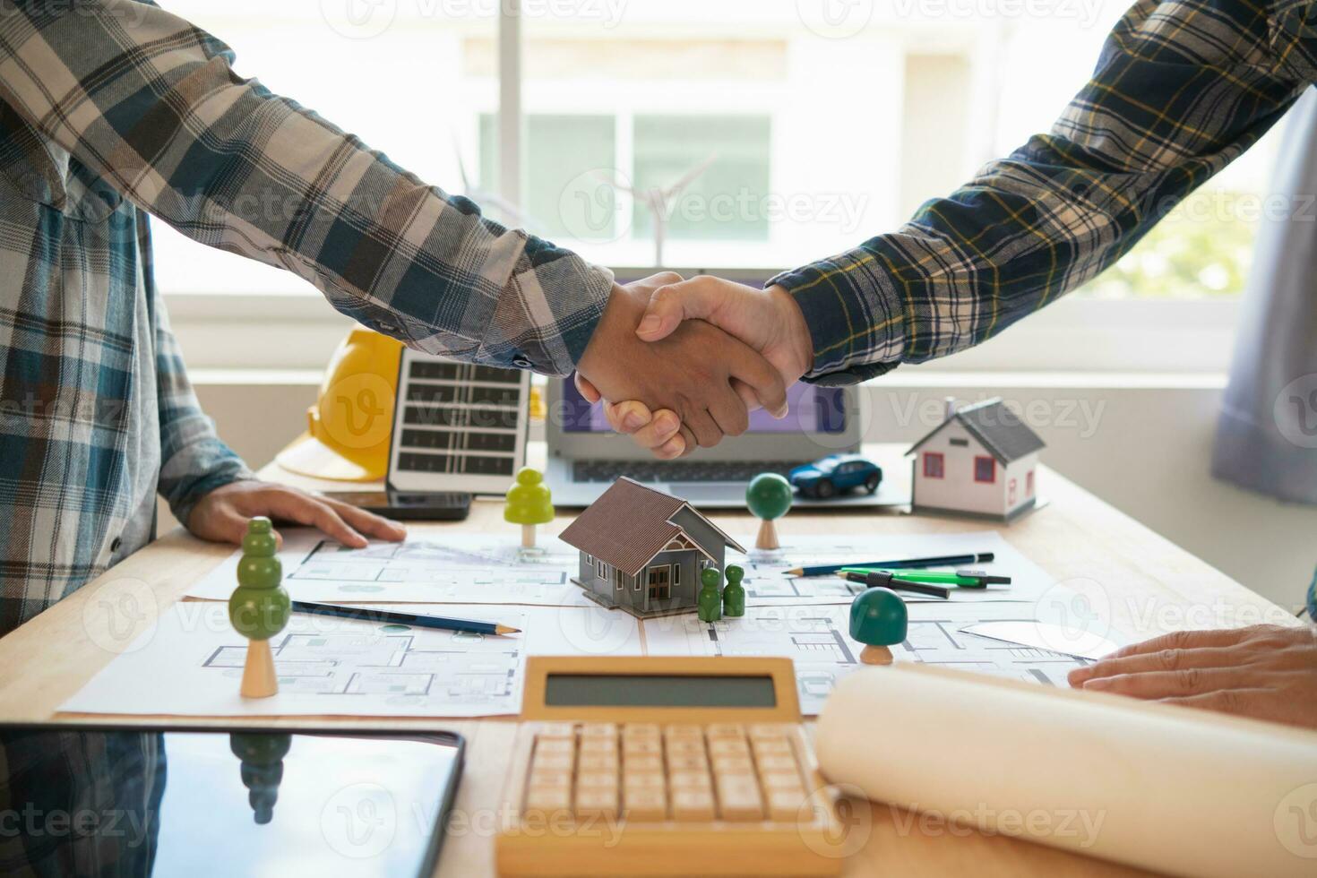 Architects and engineers join hands to congratulate when discussing and successful cooperation in planning construction project. Team of engineers and architects join hands in office after successful photo