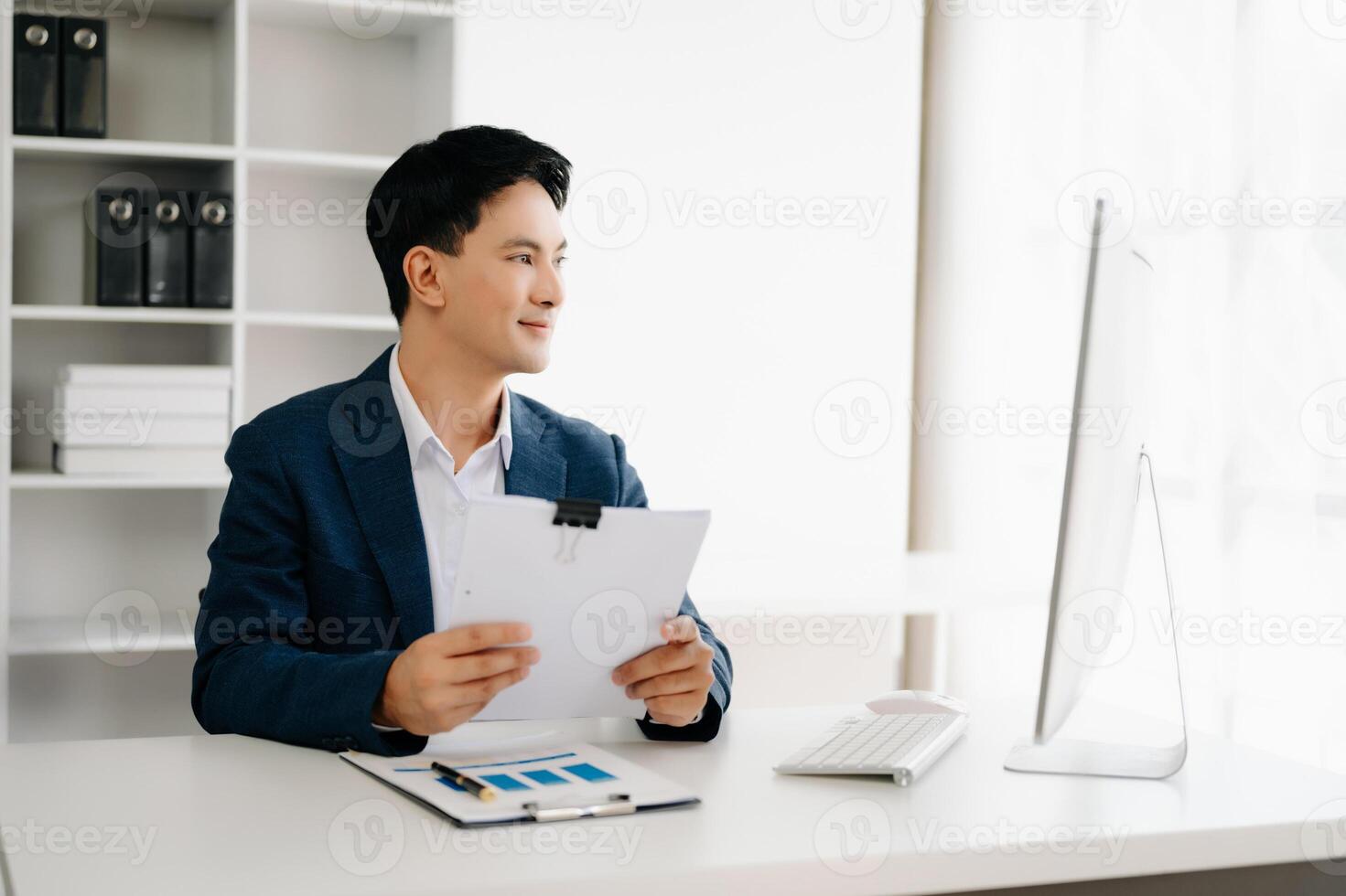 Business man using tablet and laptop for doing math finance on an office desk, tax, report, accounting, statistics, and analytical research concept in office photo