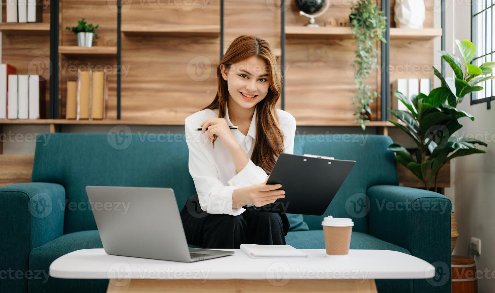 Business woman using tablet and laptop for doing math finance, tax, report, accounting, statistics, and analytical research concept on sofa in home office photo