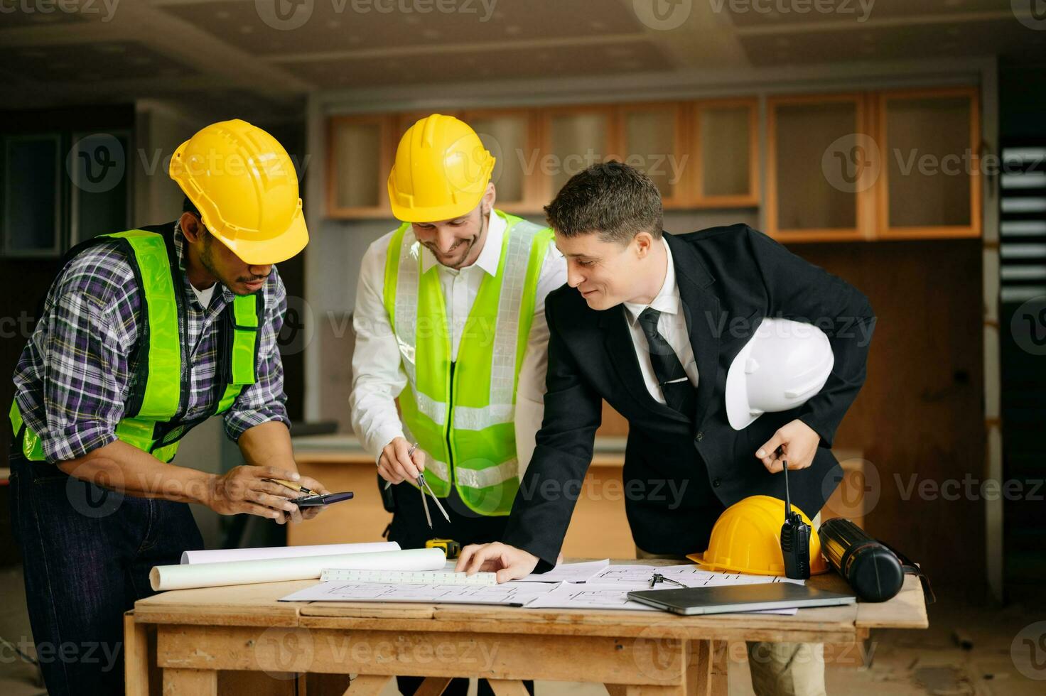 Engineers are discussing data working and laptop or tablet with architectural project at new construction site on big project. interior photo