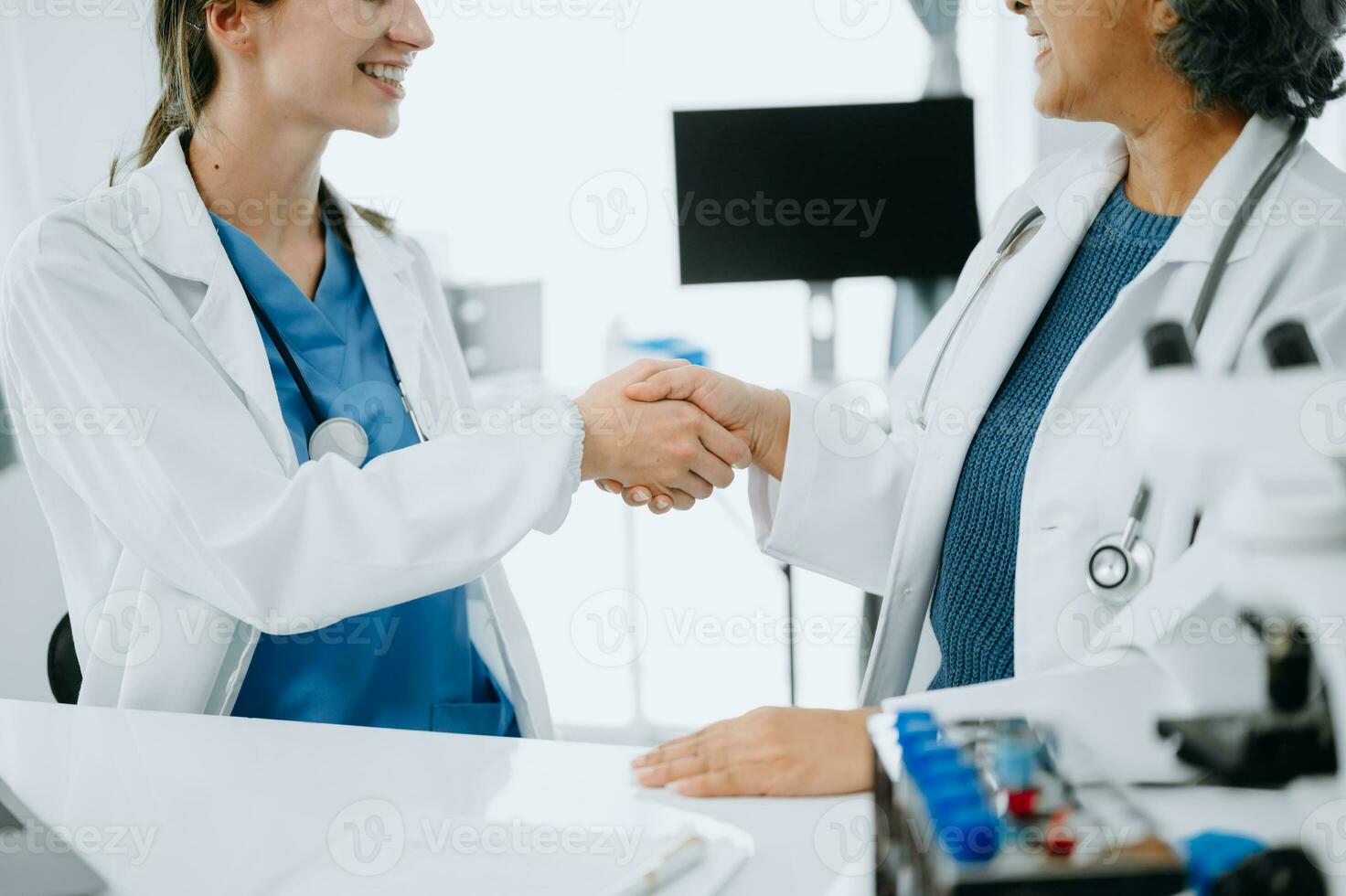 Doctor, handshake and partnership in healthcare, medicine or trust for collaboration, unity or support.Team of medical experts shaking hands in teamwork for or success in clinic or hospital photo
