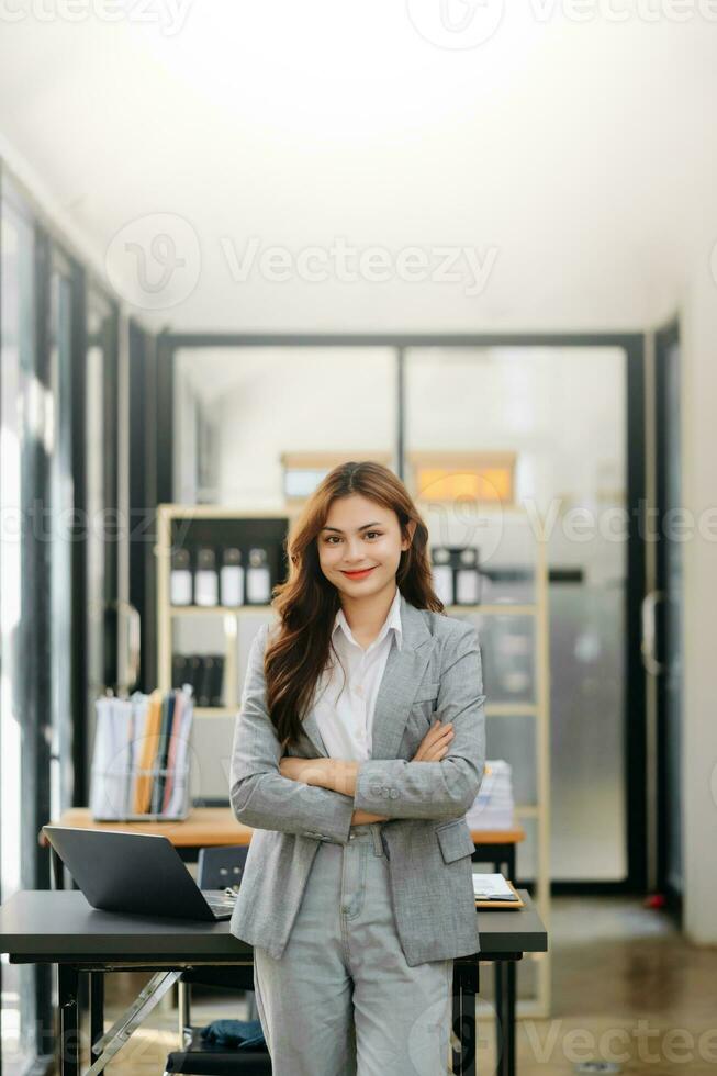 Confident business expert attractive smiling young woman holding digital tablet  on desk in office. photo