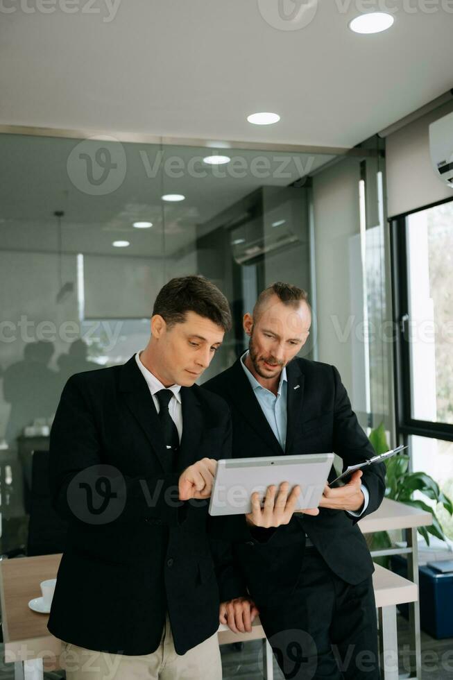 Kind leader executive manager share and discuss business solutions plan ideas on tablet with male marketing manager in modern office. photo