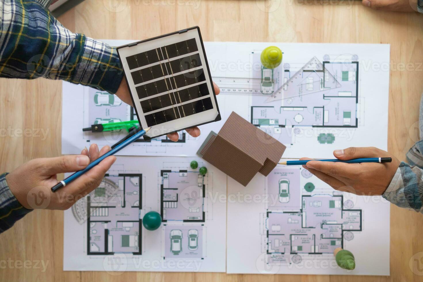 team of renewable energy engineers are talking to architects to make structure of house support weight of  solar panels. Concept of installing solar cells to use as renewable energy photo