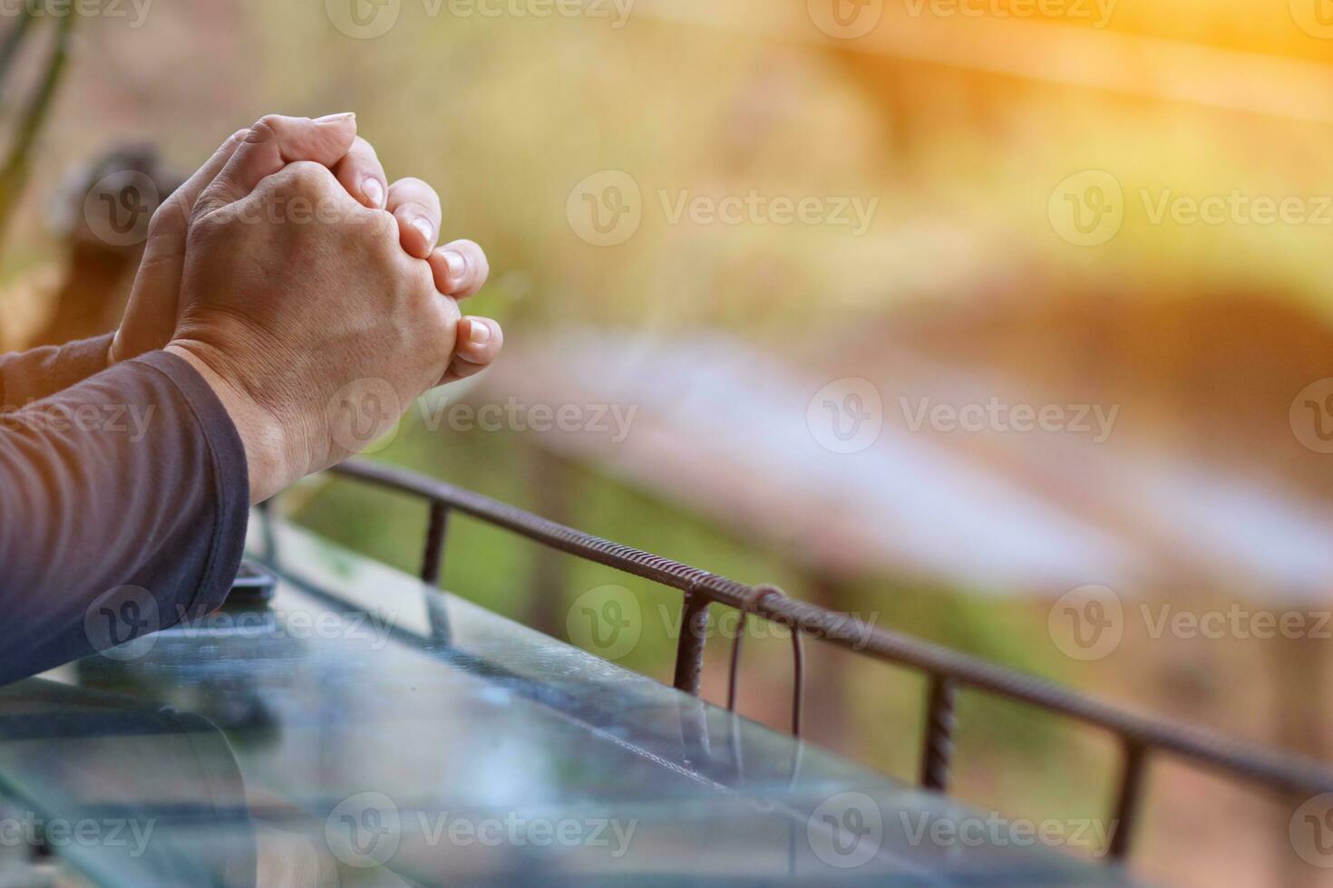 The hand of a young man praying to God for the power of God to fulfill the request of the Christian faith. The young man prayed to God for blessings based on his faith and power of faith in Him. photo