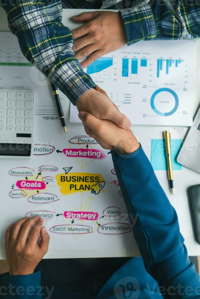 Businessmen and investors form a group of startups and business plans together in a meeting room. A group of startup entrepreneurs are discussing investment plans and profits. photo