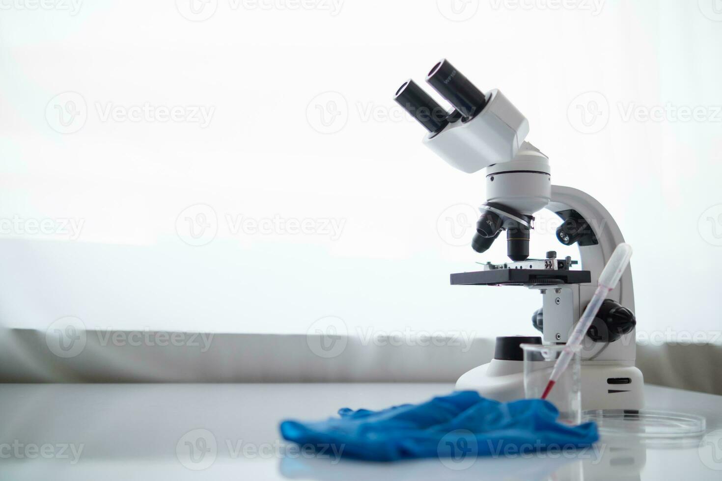 medical gloves and microscope are placed ontable in lab to prepare virologists who want to use lab to examine samples of virus they received from epidemic. Medical equipment for use in laboratorie photo