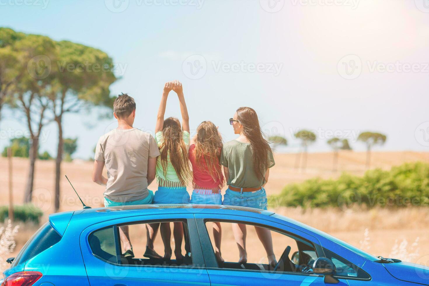 padres y dos niños pequeños en vacaciones de verano en coche foto