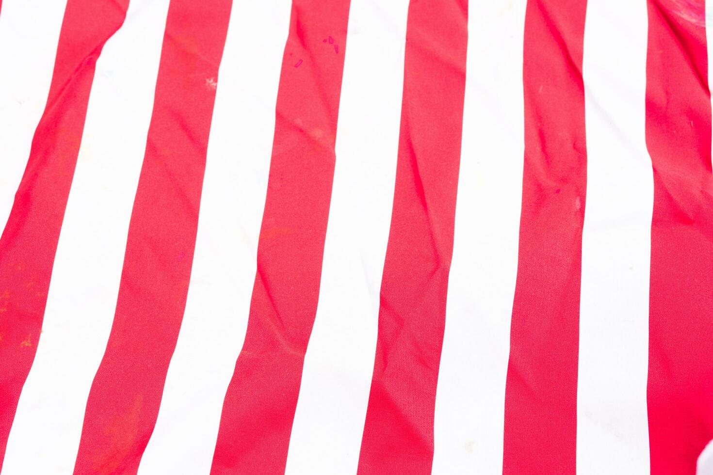 horizontally-oriented flag background with red and white stripes filling the majority of the frame photo