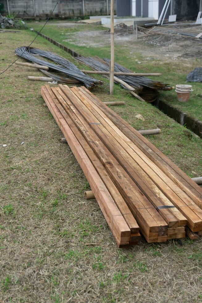 Wood timber construction material. Closeup big wooden boards. Stacked wooden beams of square section for house construction photo