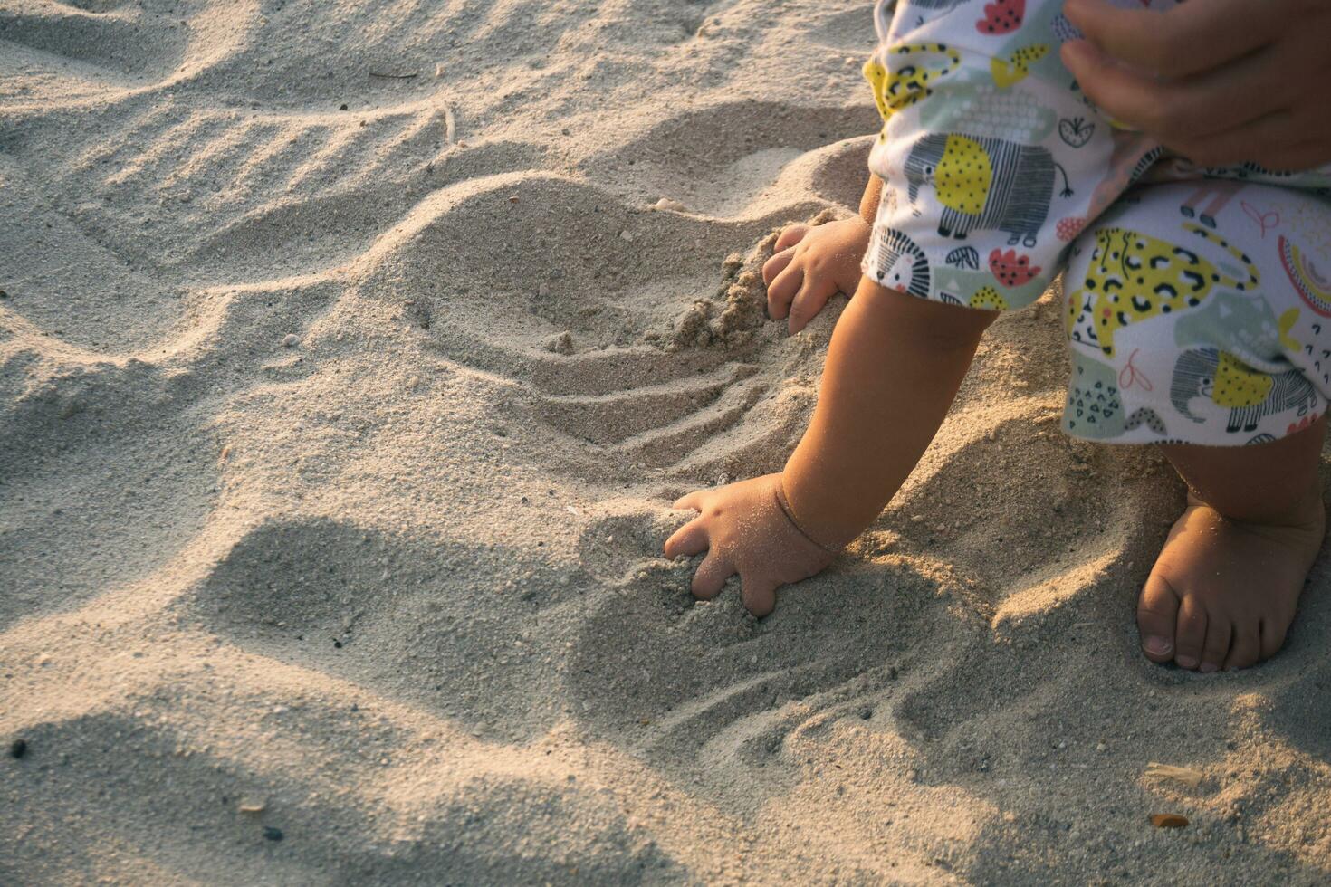 close up of kid hands digging on the beach sand photo