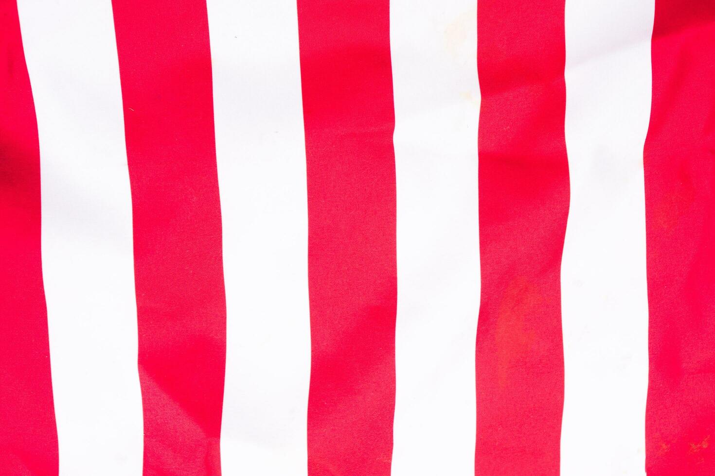 horizontally-oriented flag background with red and white stripes filling the majority of the frame photo