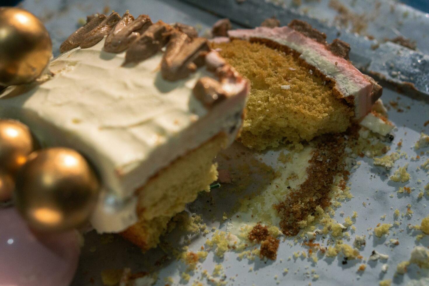 rebanada de delicioso cumpleaños pastel en plato en blanco mesa en ligero antecedentes con borroso antecedentes foto