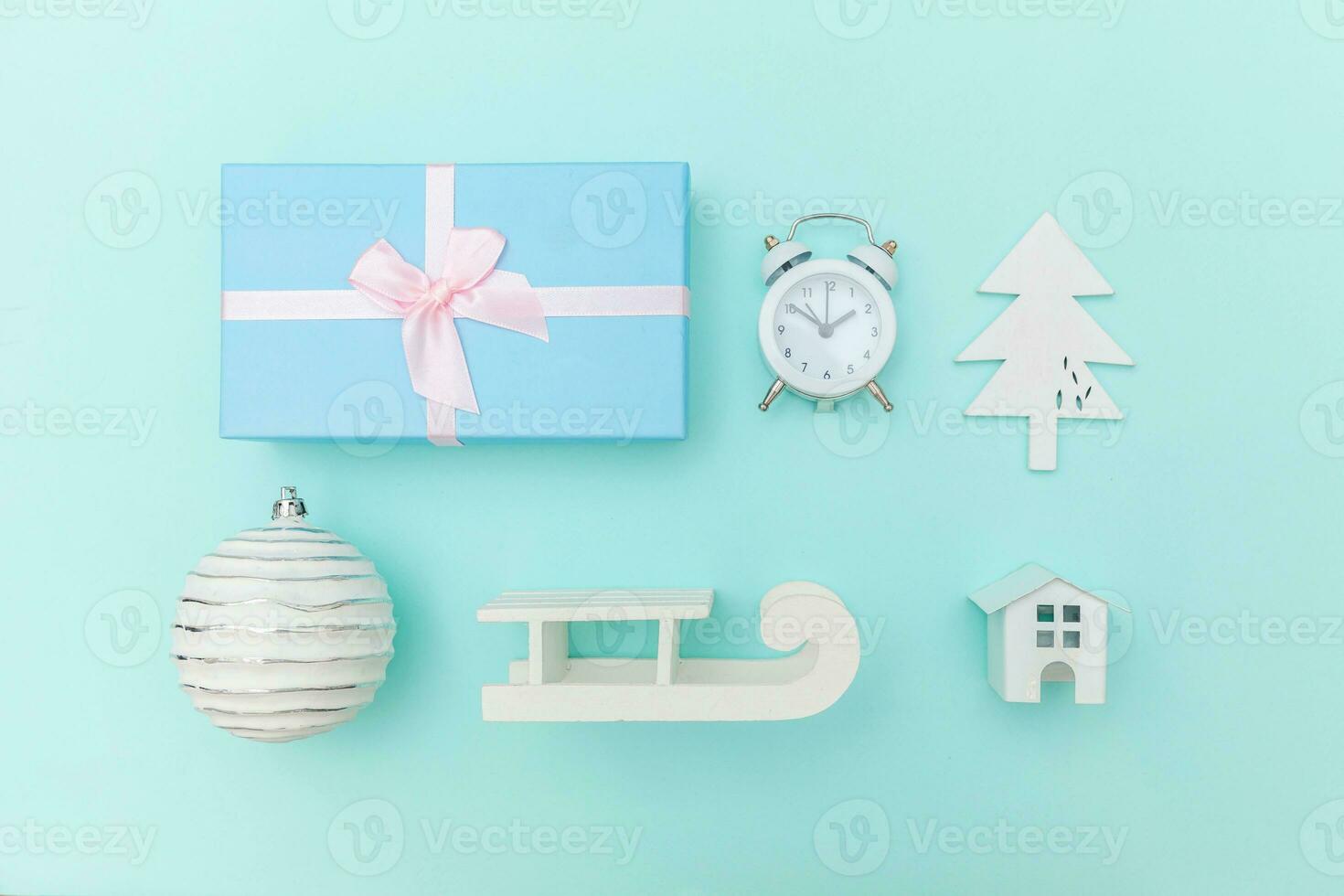 Simply minimal composition winter objects ornament sled fir tree ball gift box isolated on blue pastel trendy background photo
