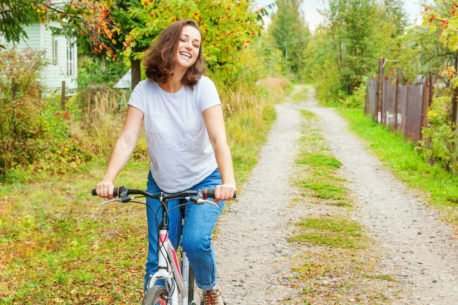 Young woman riding bicycle in summer city park outdoors. Active people. Hipster girl relax and rider bike. Cycling to work at summer day. Bicycle and ecology lifestyle concept. photo