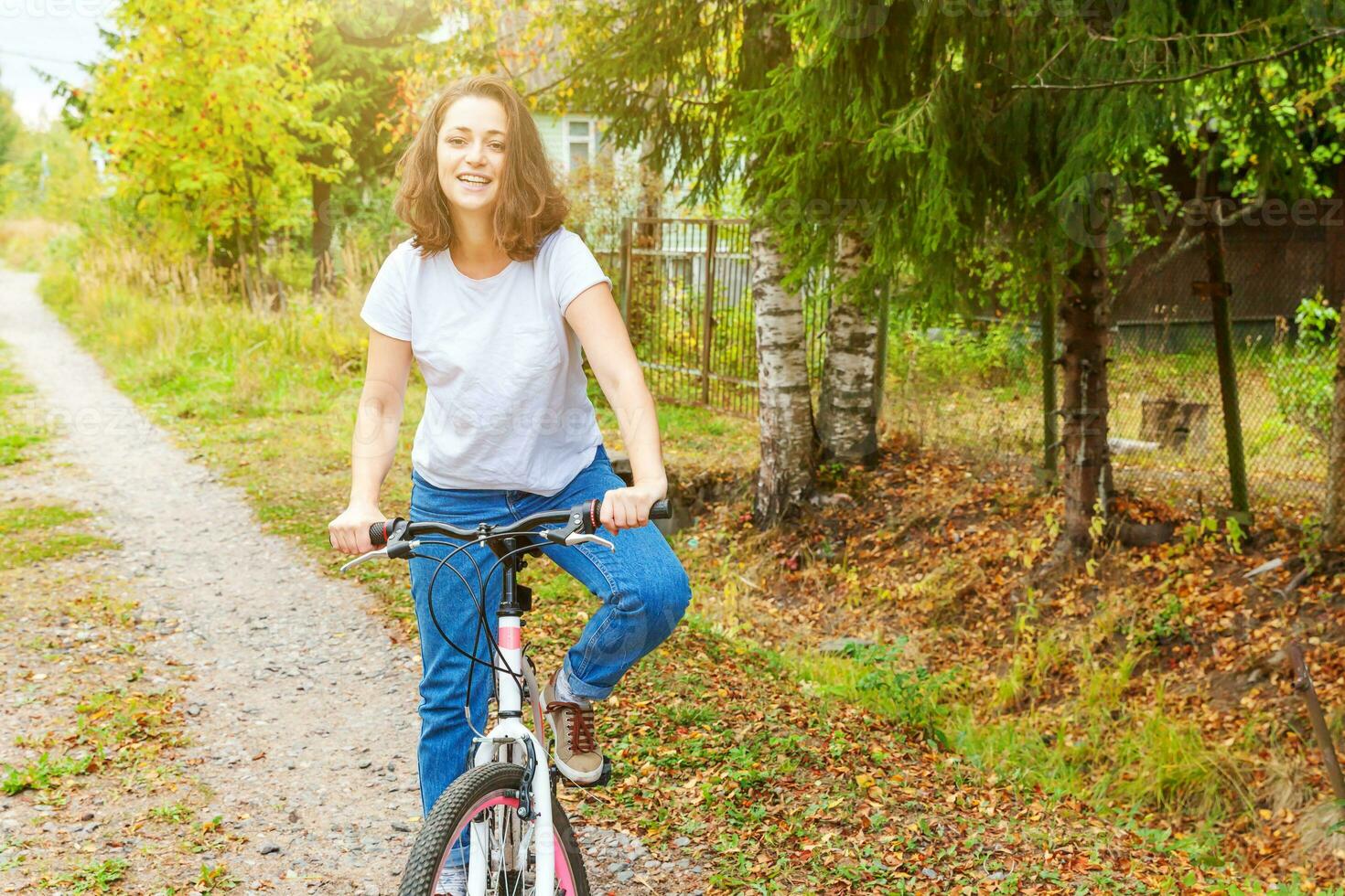 Young woman riding bicycle in summer city park outdoors. Active people. Hipster girl relax and rider bike. Cycling to work at summer day. Bicycle and ecology lifestyle concept. photo