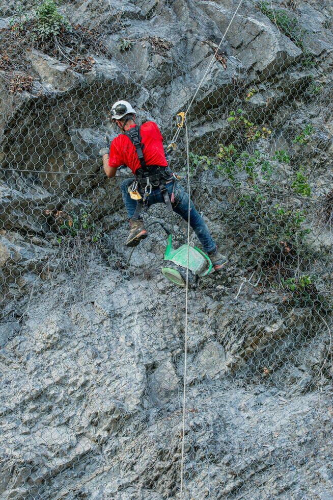 Climber placing safety nets to avoid falling rocks photo