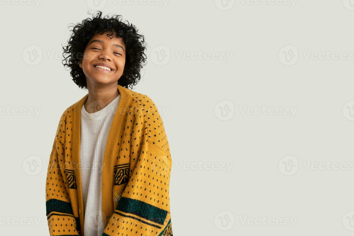 Beautiful african american girl with afro hairstyle smiling isolated on white background with copy space. Young african woman with curly hair laughing. Freedom happiness carefree happy people concept. photo
