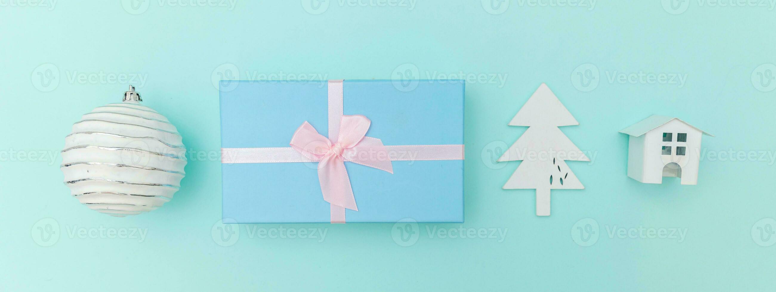 Simply minimal composition winter objects ornament fir tree ball gift box isolated on blue pastel trendy background photo