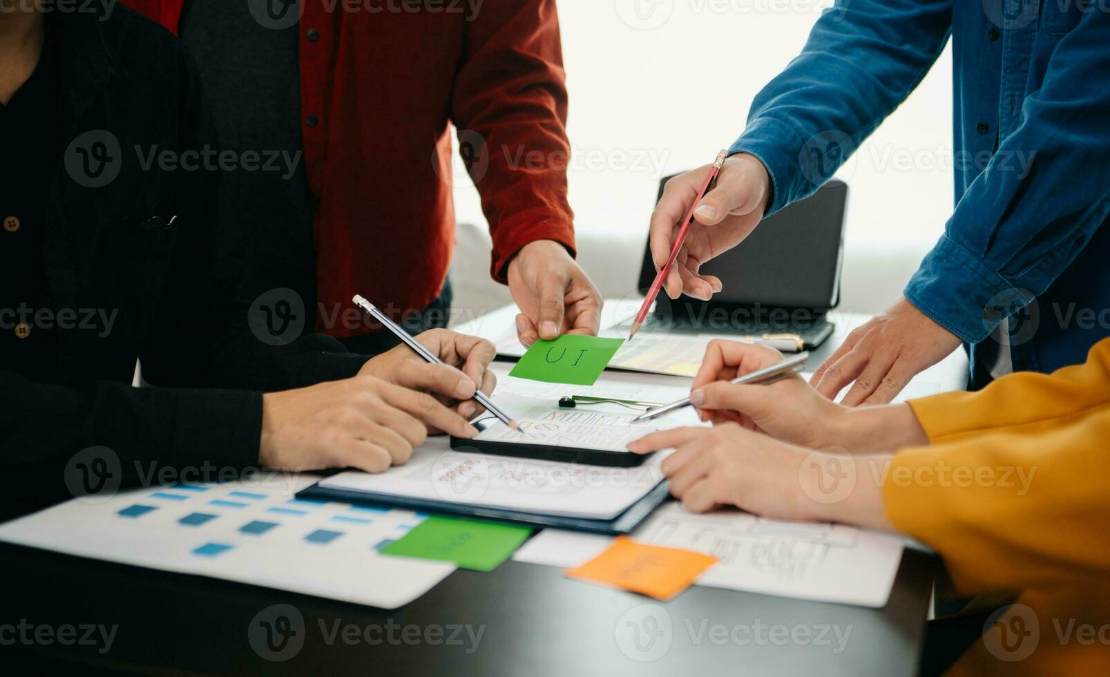 UX developer and ui designer brainstorming about mobile app interface wireframe design with customer breif and color code at office. photo
