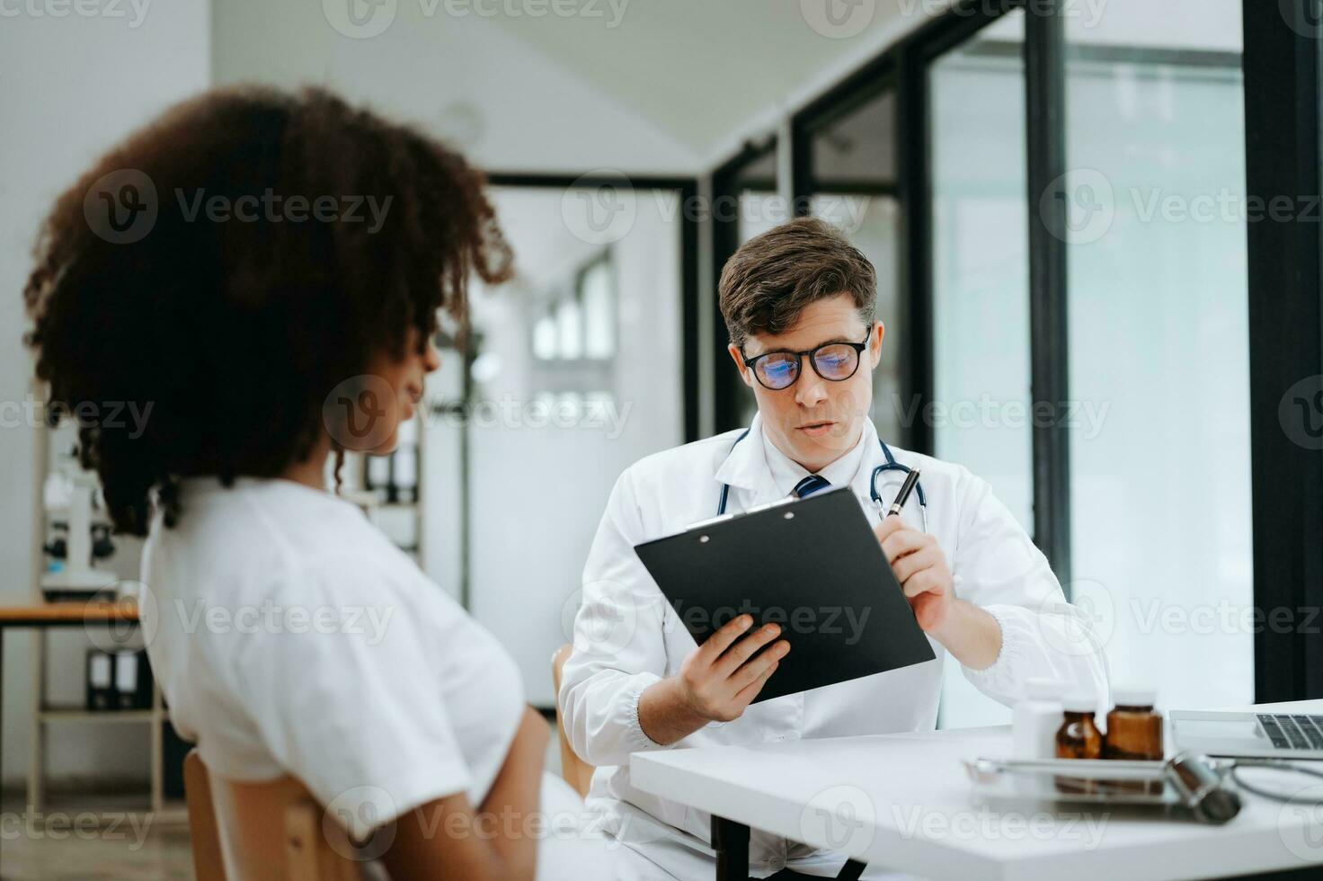 médico y paciente discutiendo algo mientras están sentados en la mesa. concepto de medicina y atención de la salud. foto