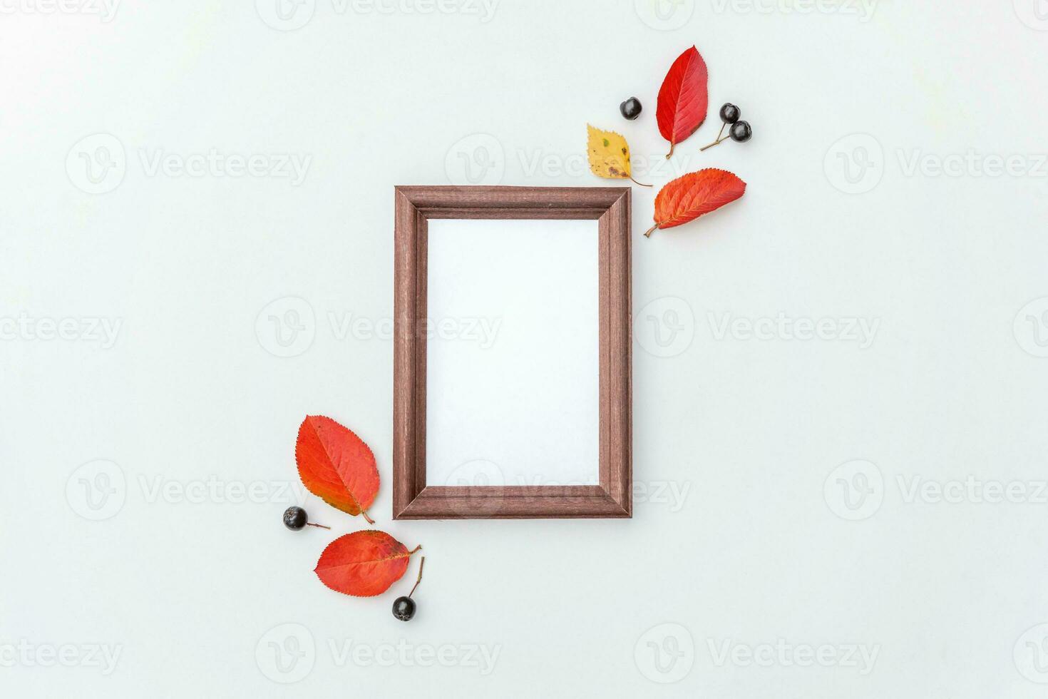 Autumn floral composition. Vertical photo frame mockup chokeberry rowan berries colorful leaves on white background. Fall natural plants ecology fresh wallpaper concept. Flat lay top view, copy space