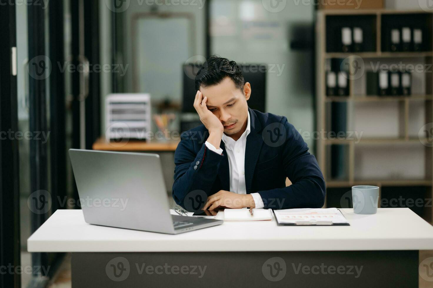 Overworked young Asian businessman office worker suffering from neck pain after had a long day at her office desk. office syndrome concept photo