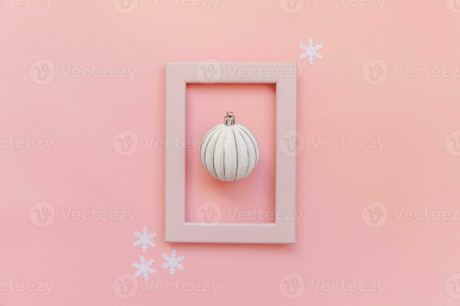 Simply minimal composition winter objects ornament ball in pink frame isolated on pink pastel trendy background photo