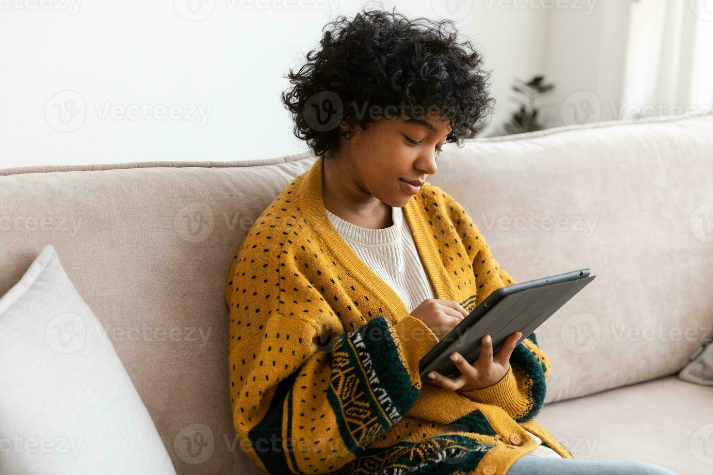 African american girl holding digital tablet touch screen typing scroll page at home. Woman with mobile tech device surfing internet using social media apps playing game. Study work shopping online. photo