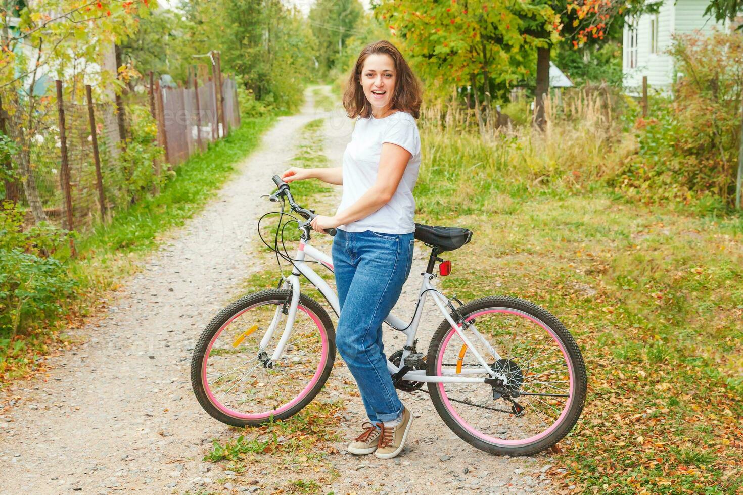 Young woman riding bicycle in summer city park outdoors. Active people. Hipster girl relax and rider bike. Cycling to work at summer day. Bicycle and ecology lifestyle concept. photo