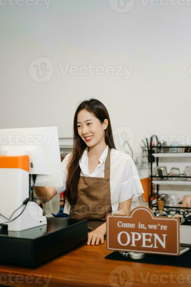 Asian female coffee shop owner in a coffee shop photo