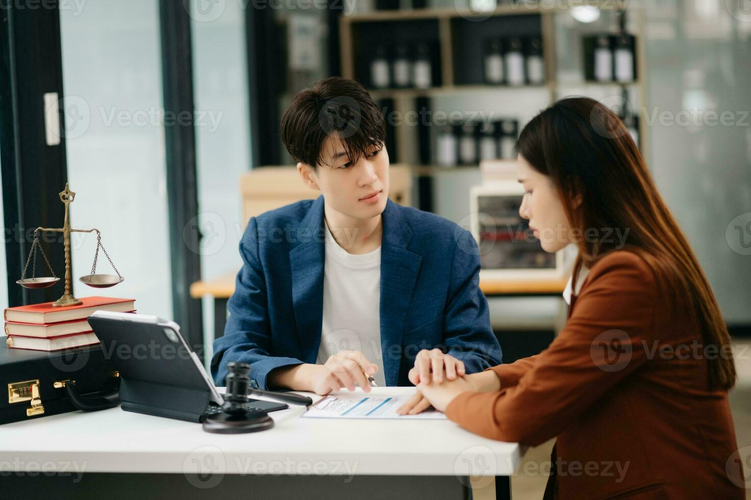 Business people compassionately holding hands and discussing contract papers with laptop and tabletat in office room. photo