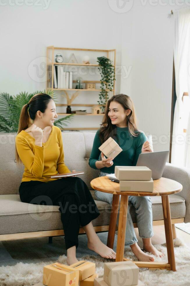 Starting small businesses SME owners, two check online orders Selling products working with boxs freelance work at office using tablet and laptop  marketing, packaging, concept photo