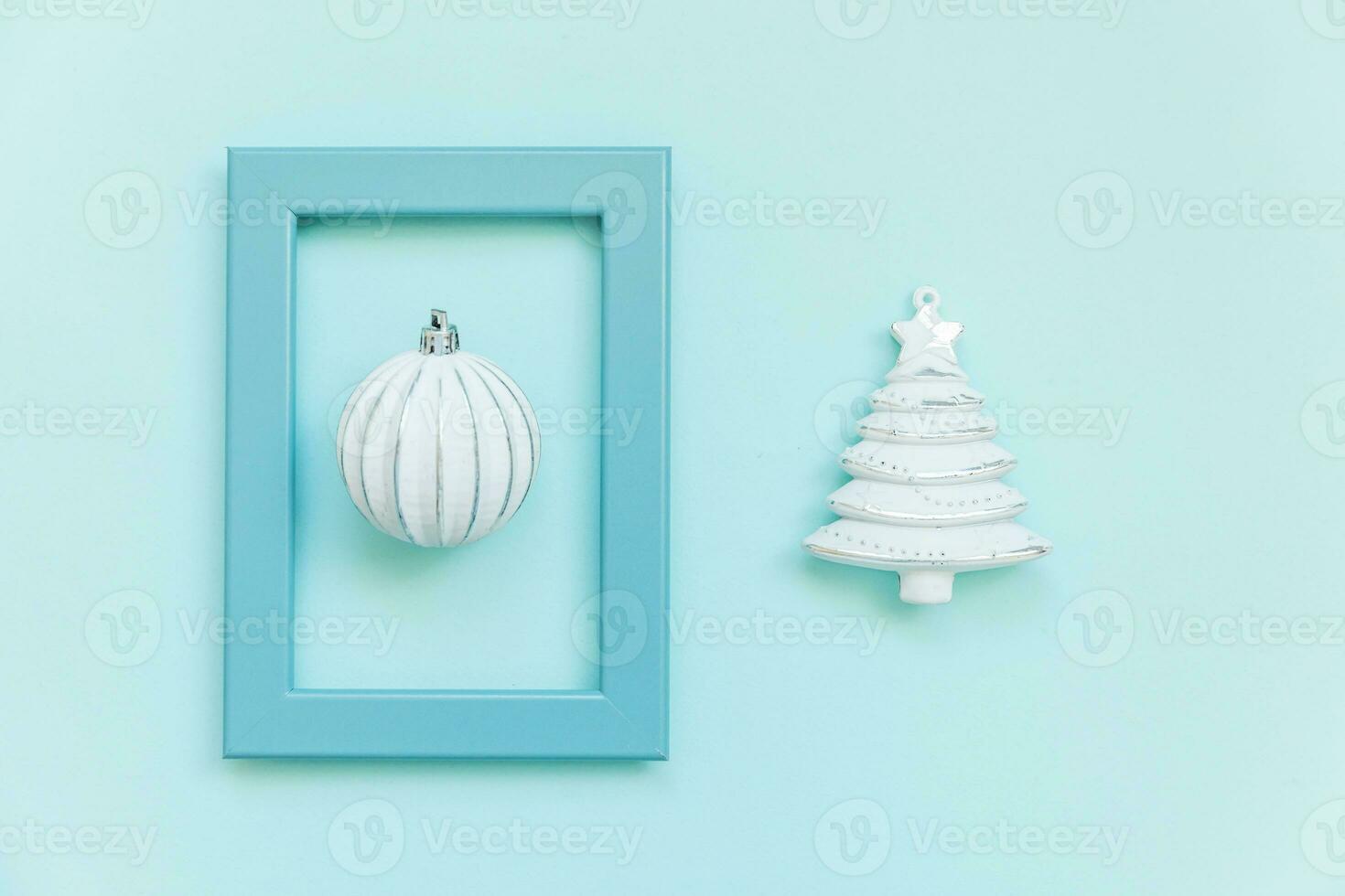 Simply minimal composition winter objects ornament fir tree ball in blue frame isolated on blue pastel trendy background photo